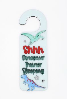 a white door hanger with an image of a dinosaur on it