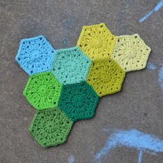 four crocheted hexagons are on the ground