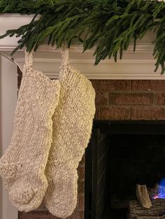 two knitted stockings hanging from a fireplace mantel