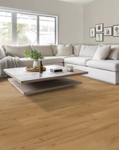 a living room with white furniture and wood flooring