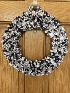 a black and white wreath hanging on a door