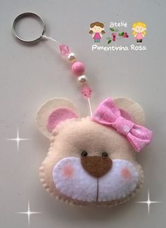 a stuffed animal keychain with a pink bow on it's head and ears