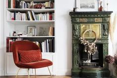 a living room filled with furniture and a fire place next to a bookshelf