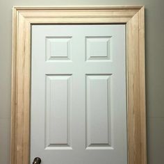 a white door with two wooden frames on the front and back sides, in a room