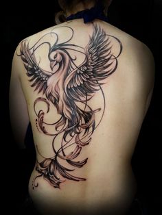 the back of a woman's body with an intricate tattoo design on her left side