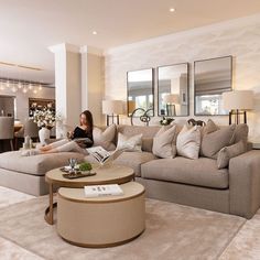 a woman sitting on top of a couch in a living room next to a table