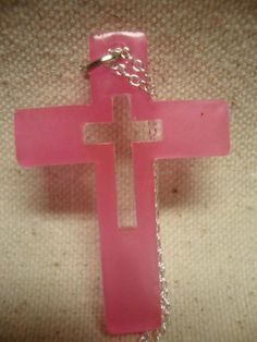 Hot pink resin cross pendant, made with glow in the dark pigment, on silver 18 inch chain. Lobster claw clasp. Cross is approximately 2 inches tall. Pink Cross Jewelry For Wedding, Pink Cross Jewelry, Pink Cross Necklace For Gifts, Pink Cross Pendant Jewelry As Gift, Pink Cross-shaped Jewelry Gift, Cross Pendant Necklace, Cross Pendant, Glow In The Dark, Cross Necklace