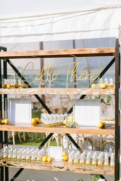 a display case filled with lots of bottles and lemons on top of wooden shelves