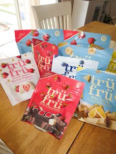 five bags of fruit snacks sitting on top of a wooden table