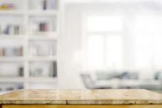 a wooden table with blurry bookshelves in the background