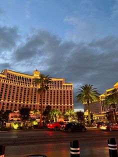 the las vegas hotel and casino is lit up at night with palm trees in the foreground