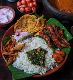 a plate full of rice, meat and vegetables on a table with other foods in bowls