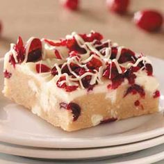 a piece of cake with white frosting and cranberry toppings on a plate