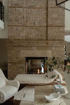 a living room filled with furniture and a fire place next to a wall mounted fireplace