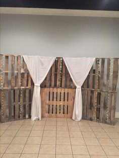 the room is decorated with wooden pallets and white drapes