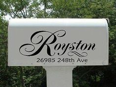 a white mailbox with the name ropston on it in front of some trees