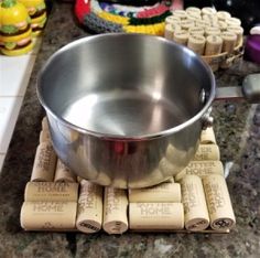 a stainless steel bowl sitting on top of corks next to wine cork coasters