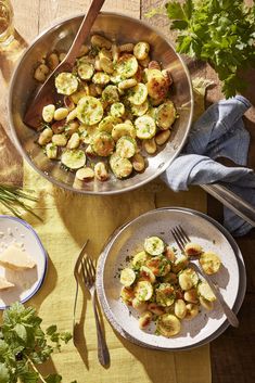 a pan filled with food on top of a table next to plates and utensils