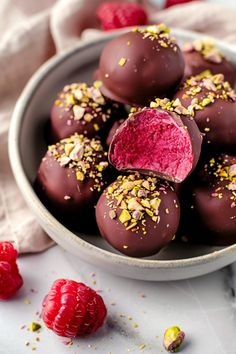 a bowl filled with chocolate covered raspberry truffles