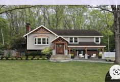 a large house sitting in the middle of a lush green field