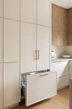 a kitchen with white cabinets and wood flooring