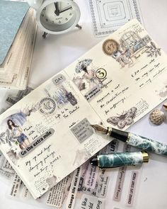 an old postcard and fountain pens on top of some papers