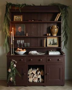 a wooden hutch with candles and pictures on it