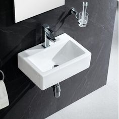 a white sink sitting next to a black wall