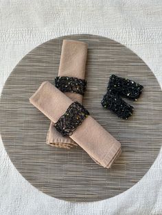 three napkins on a plate with black beads