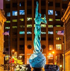 a statue in the middle of a city at night