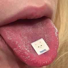 a close up of a person's tongue with the word travel on it