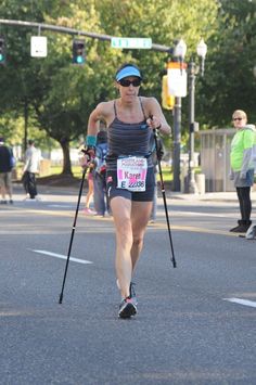 a woman with crutches is running in a race while holding her cross - country skis