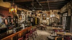 the inside of a restaurant with many tables and chairs, pictures hanging on the wall