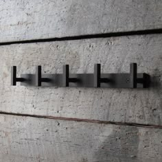 three metal hooks on the side of a wall