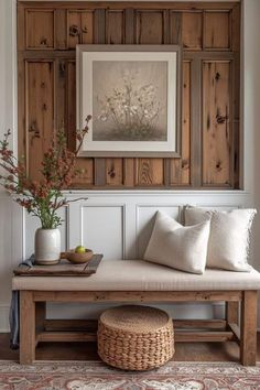 a wooden bench sitting in front of a wall with pictures on the wall above it