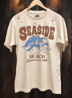 Country Deep Seaside Beach Summer of 1988 Vintage unisex distressed T shirt in vintage natural color Vintage country western cowboy T shirt 40 Singles Jersey 100% Cotton Premium quality ringspun and compacted cotton Fine Cotton Jersey that is pigment dyed for a more vintage look Features tears and destroyed features at neck and on body Each piece is unique as this process is done by hand! 3.8 oz Made In USA Every garment dye item can be a slightly different shade in color and distressed since th Faded Distressed T-shirt For Summer, Summer Distressed Grunge T-shirt, Distressed Grunge T-shirt For Summer, Vintage Washed T-shirt For Spring, Summer Graphic Tee With Bleached Design, Summer Graphic Tee With Bleached Detail, Faded Vintage Summer Tops, Summer Distressed Grunge Tops, Distressed Grunge Tops For Summer