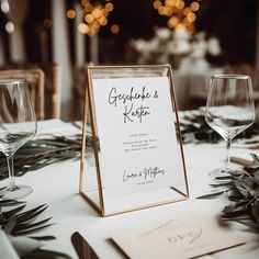 a close up of a sign on a table with wine glasses and napkins in front of it