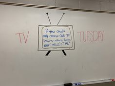 a white board with writing on it in front of a wall that has a tv drawn on it