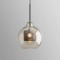 a glass and metal light hanging from a ceiling