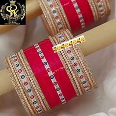 red and gold colored bangles with white beads on them are sitting next to each other