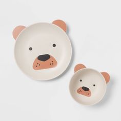 two small bowls with bears on them are shown in the shape of bear head plates