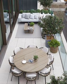 an instagram page with a table and chairs in the middle, surrounded by potted plants