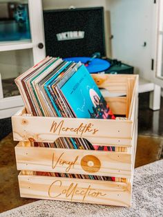 a wooden crate filled with vinyl records on top of a counter next to a record player