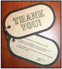 two thank you tags sitting on top of a wooden table