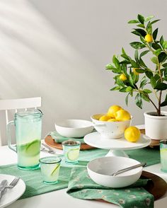 the table is set with lemons, water, and other dishes for two people to eat