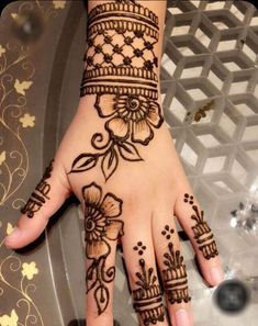 henna tattoo on the palm of a woman's hand with flowers and leaves