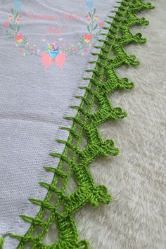 the green crocheted trim is being used to make a blanket