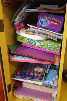 a yellow bookcase filled with lots of children's books on top of each other