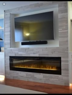 a flat screen tv mounted on the wall above a fireplace