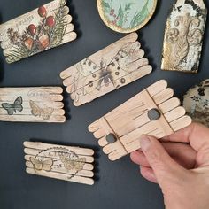 a person is holding some wooden clothes pins with pictures on them and other things around it